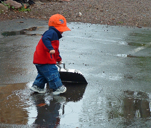 child sweeping rain