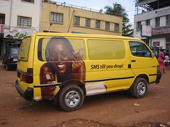 SMS till you drop: mobile phone ad on van in Kampala, Uganda
