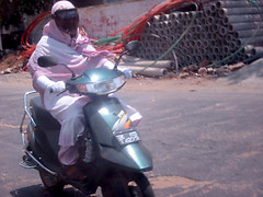 woman wearing hijab riding a scooter