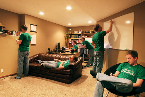 Young man in green Illinoise t-shirt in his room office with the multiplicity effect