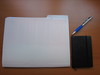 folder of prepared papers, Moleskin notebook, ballpoint pen