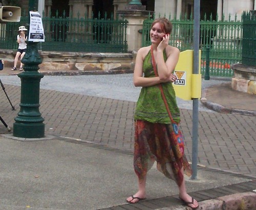On the phone - attendee at Invasion Day Rally and March, Parliament House, George St, Brisbane, Queensland, Australia 070126
