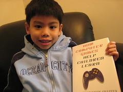 smiling kid holding video game learning book