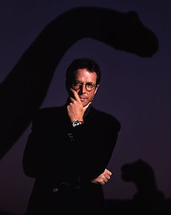 Michael Crichton with a dinosaur in the background