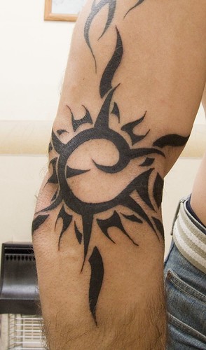 Great design of a Tribal Sun Tattoo done on the arms