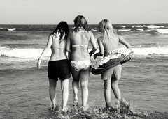 Three girls walking into the sea to have fun
