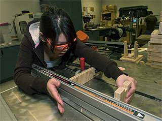 Vanna Lee sets up a table saw as she makes a jewelry box for her class in manufacturing technology