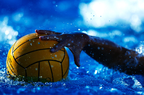 A UCSD women's water polo player reaches for the ball.