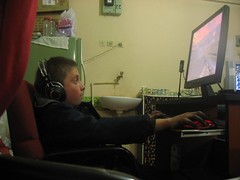 Kid in Turkish internet cafe absorbed in computer game (Tercan, Turkey)