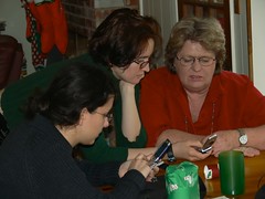 Younger people explaining text messaging to older person by jim_mcculloch