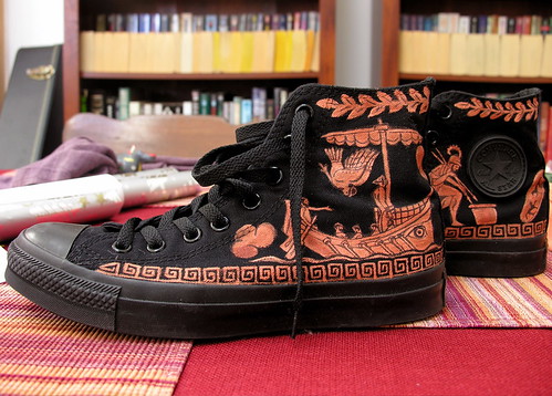 Black Chuck Taylor sneakers, with Greek-style vase           painting on them.