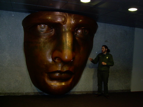 statue of liberty face image. National Park Service Ranger standing next to a replica of the face of the Statue of Liberty inside the museum within the pedestal of the statue
