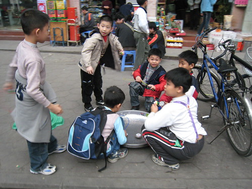 Kids playing with their tops in the streets and back alleys near the Chen Family Temple in Guangzhou, China