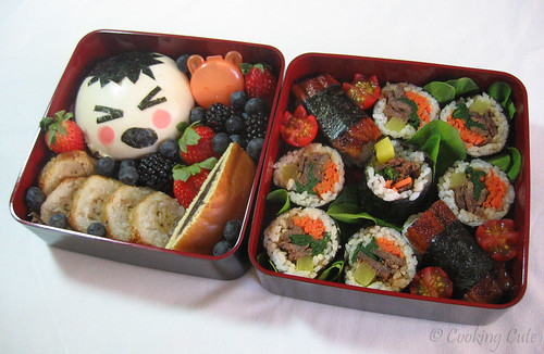 [first bento tier with steamed bun, grilled banana cake, and fruit; second bento tier with kim bap and unagi nigiri sushi]
