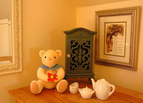 Staging for small north bedroom, with teddy bear, tea set and Alice in Wonderland quote. Creamy warm, friendy and familiar, with a little whimsy. by Wonderlane