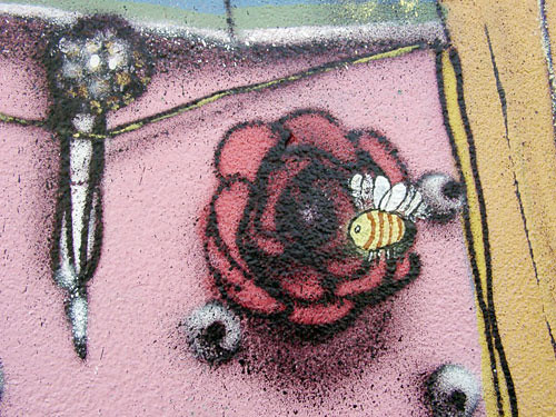 graffiti of a flower, a bee hovering over, maybe a microphone in the background?