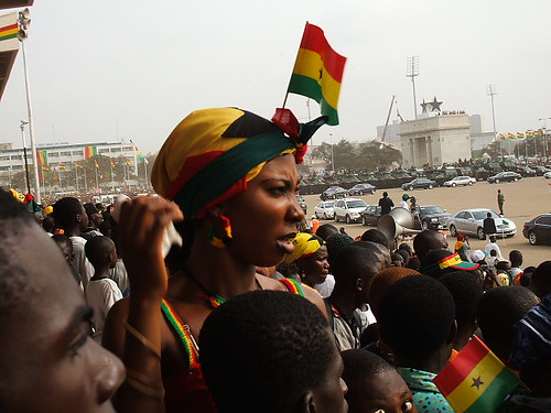 A Ghanaian woman, adorned in the colours of Ghana's national flag