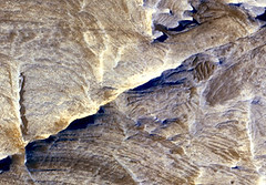Tectonic fractures within the Candor Chasma region of Valles Marineris, Mars, retain ridge-like shapes as the surrounding bedrock erodes away. This points to past episodes of fluid alteration along the fractures and reveals clues into past fluid flow and geochemical conditions below the surface. Credit: NASA