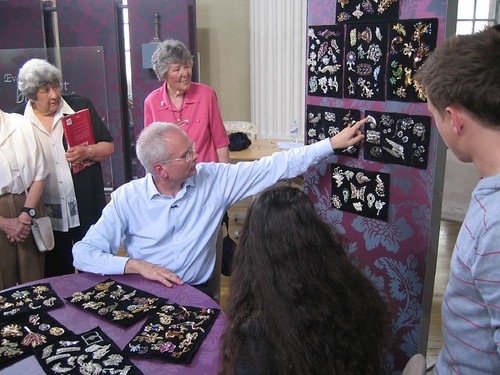 Expert Geoffrey Munn pointing at one of the brooches