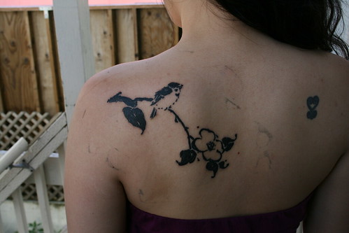 Leaves and a bird tattoo on her back