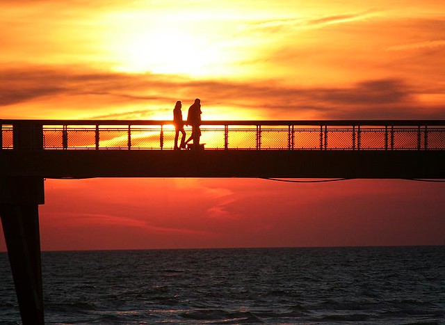 Holding Hands at Sunset. Young couple enjoying a sunset walk on the Ft. 