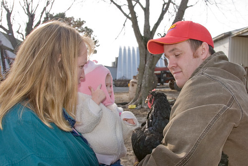 Carl showing a chicken to Abigail