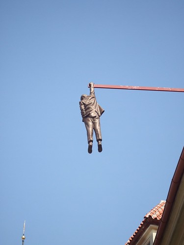 A bronze statue hanging from one of the buildings representing the fall of communism.