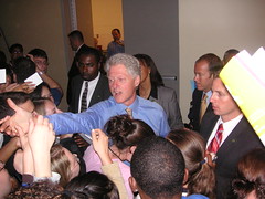 Bill Clinton reaches for something to sign