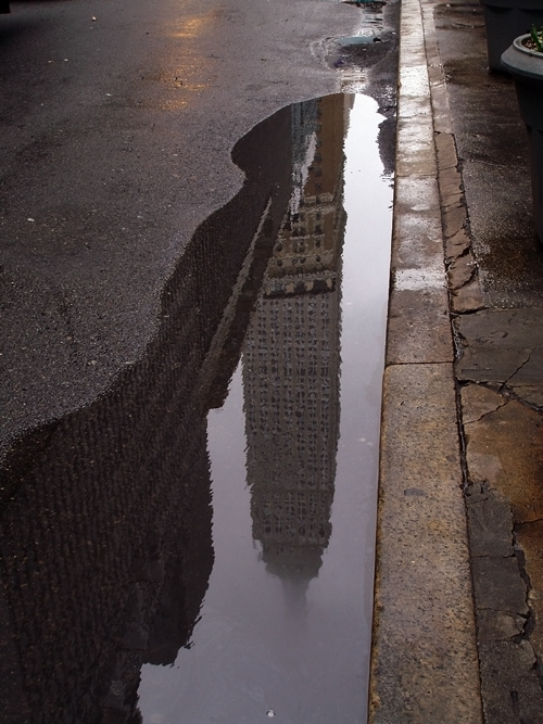 reflection of Empire State Building in puddle