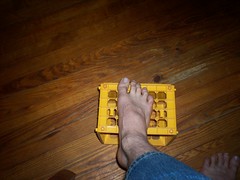 Luca's foot resting on a yellow plastic basket.
