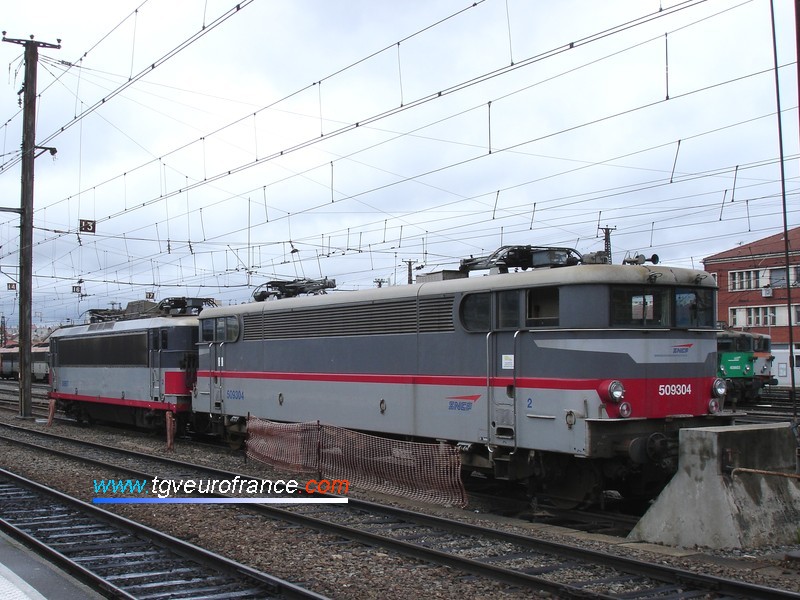 Deux locomotives électriques monotension en livrée Multiservice stationnent au dépôt SNCF de Toulouse.