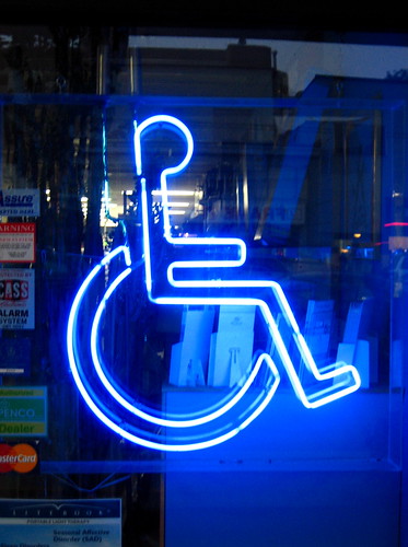 A wheelchair symbol lit up in florescent light