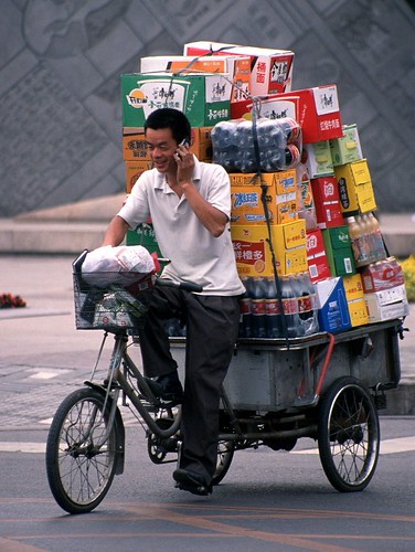 Un commerciante trasporta la sua merce per le vie di Pechino