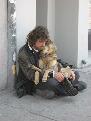 Homeless man cuddles dog