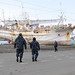 Sailors walk toward fishing boat washed ashore following tsunami.