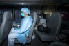 A health worker with protective suits sitting with people (R) who came into close contact with the Korean Mers patient arrive at Lady MacLehose Holiday Village in Sai Kung, where they will spend two weeks in quarantine, in Hong Kong, China