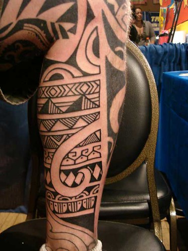 Daniel DiMattia tattoos blackwork within existing tribal work.