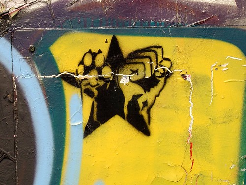 graffiti of a yellow star containing a fist and a dog paw