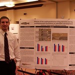 A student posing with his environmental science research poster.