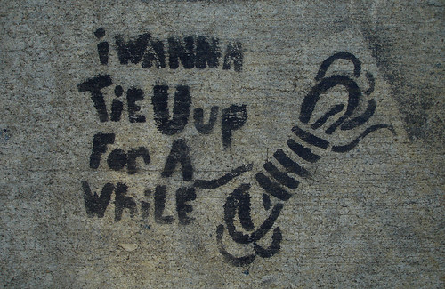stencil graffiti: i wanna tie u up for a while (with image of a twisted coil of rope)