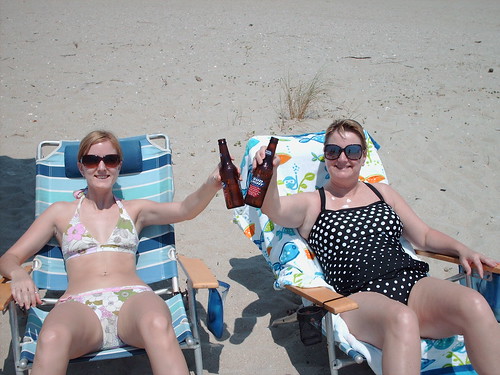 Two mature ladies in bikini partying on the beach