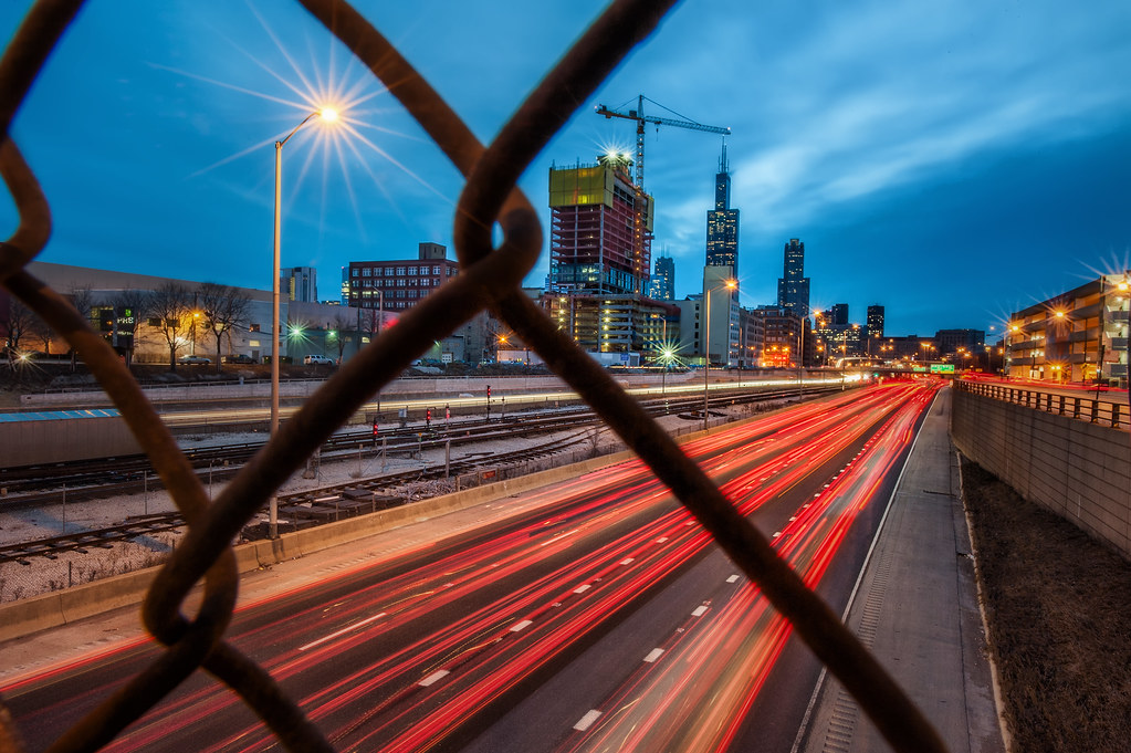 The Eisenhower Expressway from behind a chain link fence on Morgan Street.
