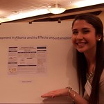 A student posing with her research poster.