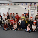 Student poses with elementary students on Dr. Seuss day