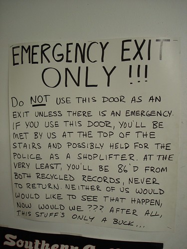  EMERGENCY EXIT ONLY!!! Do NOT use this door as an exit unless there is an emergency. If you use this door, you'll be met by us at the top of the stars and possibly held for the police as a shoplifter. At the very least, you'll be 86'd from both Recycled Records, never to return. Neither of us would like to see that happen, now would we? After all, the stuff's only a buck... 