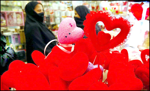 Pakistani women look "Valentines Day" items at a shop