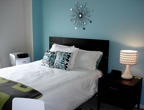 blue walls; rounded black and white lamp; modern silver wall décor