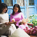 Two vietnamese lady in traditional dress sitting at home with read book
