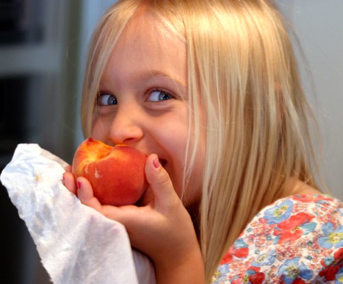 A child eating a Georgia Peach and loving it.
