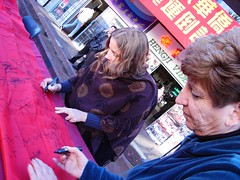 Betsy signing a Chinese banner